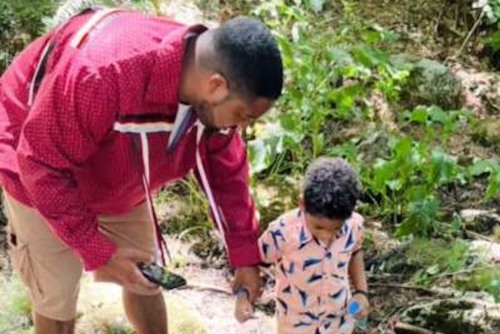 Photo of man with his son examining ground
