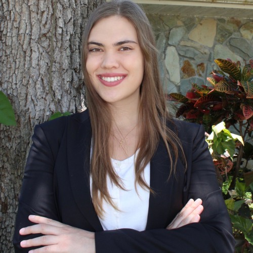 Isabella Schultz wearing a black blazer and smiling at the camera.
