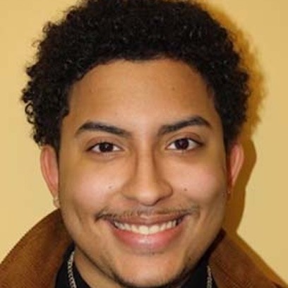 Photo of Ivan Jerez wearing red jacket against yellow background
