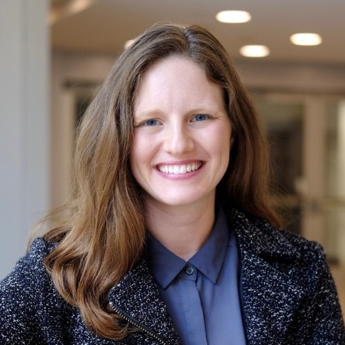 Alexandra Coooperstock wearing blue blouse and dark blue jacket against blurred university background