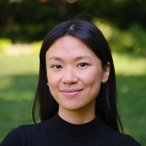 Lillian Leung who has long dark hair and is wearing a black top and standing outside in a park-like setting
