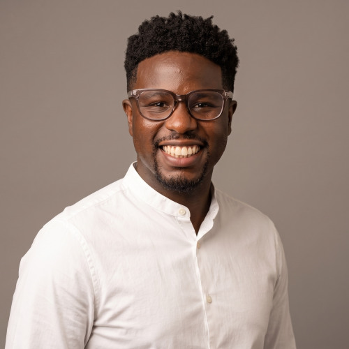 David Curtiss who is a Black male with short hair and glasses and is wearing a white collared shirt
